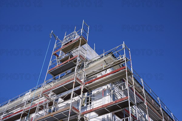 Scaffolding in front of a building under a clear blue sky, Fløibanen mountain station, Bergen,