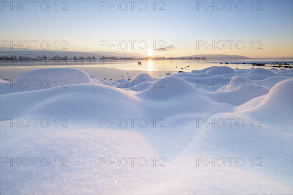 Winter lake at sunrise, many snow hills and icy atmosphere, Seegarten, Allensbach, Lake Constance,