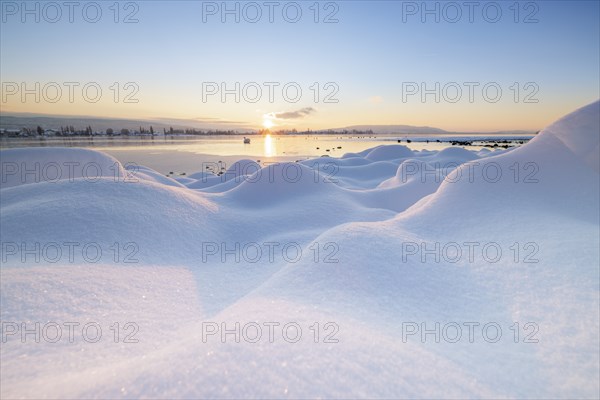 Winter snowy landscape with a lake at sunrise and some clouds, Seegarten, Allensbach, Lake