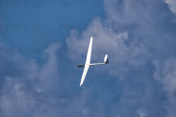 Glider plane flying in the clouds
