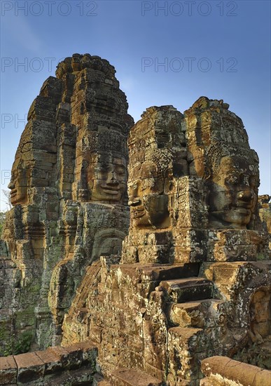 Giant stone faces at Bayon Temple at sunrise, Angkor Wat, Cambodia, Asia