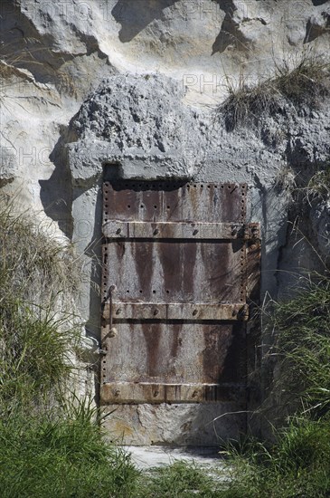 Old iron door set in a cliff face, Dunedin, South Island, New Zealand, Oceania