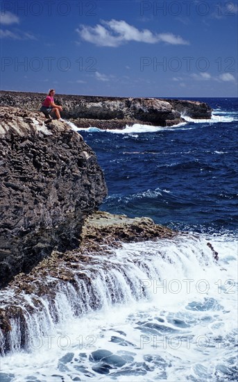 Woman watching surf on the coast, Netherlands Antilles, Bonaire, Caribbean, Caribbean Sea,