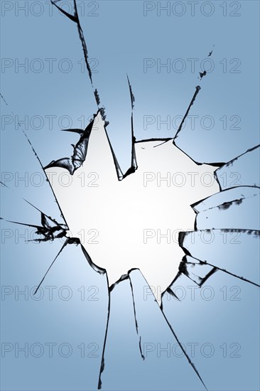 Pieces of broken glass with a hole in the center on a blue background. Texture of cracks on the