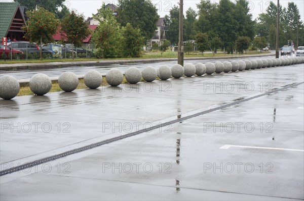Stone balls as a design course in the landscape of the city, wet road, rainy day