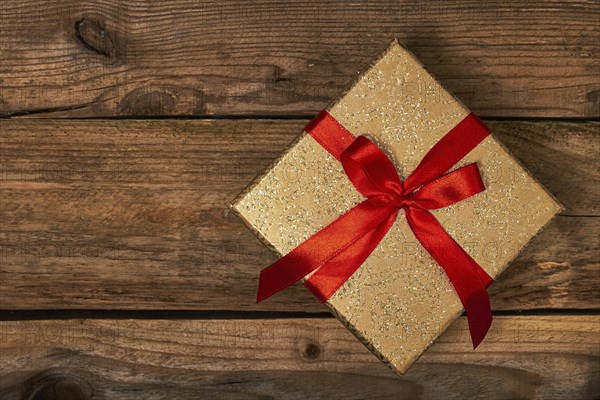 Gift present birthday Christmas concept, gift box with red ribbon on wooden background
