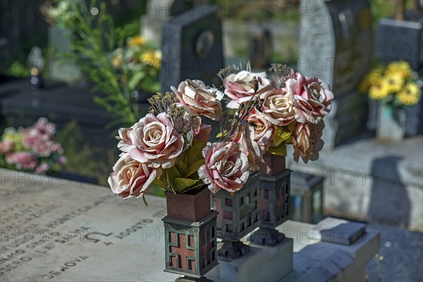 Faded plastic roses on a grave in the Staglieno Monumental Cemetery, Cimitero Monumentale di