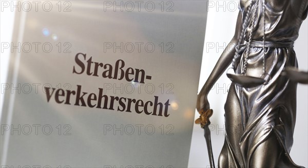 Symbolic image: Textbook on traffic law and a Justitia