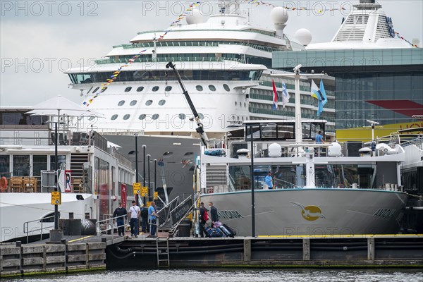 River cruise ships at the quay of the Ij, near the main railway station, passengers' luggage being