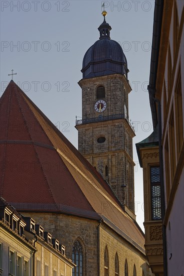 The setting sun colours the sky above an old town church Basilica of St. Martin, Rathausgasse,