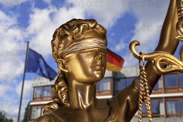 Symbolic image: Close-up of a Justitia, in the background the Federal Constitutional Court in