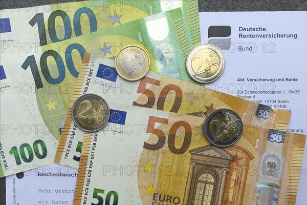 Symbol photo document pension certificate from Deutsche Rentenversicherung on cash banknotes euro