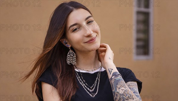 Smiling young woman with dark hair and visible tattoos poses relaxed, AI generated, AI generated