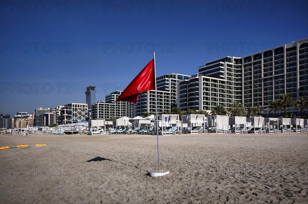 Red flag, swimming prohibited, on the beach in front of Hotel Marriot Resort Palm Jumeirah, behind