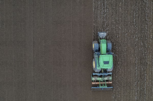 Early potatoes are laid in the soil of the field with a planting machine, tractor with roundabout