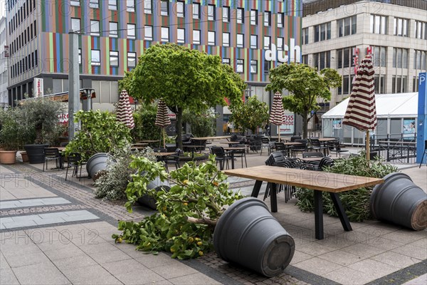 Stacked chairs and tables from various catering establishments, on Kennedyplatz, closed cafes,