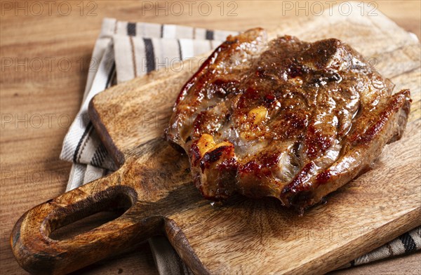 Fried steak, veal neck on the bone, cooking meat, on a wooden board, top view, no people
