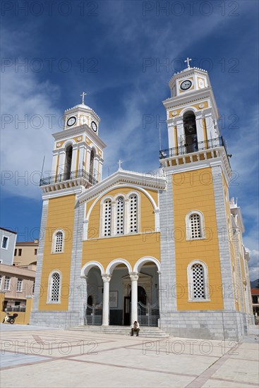 Modern church with yellow façade and two towers on a public square, Cathedral, Ypapantis Sotiros,