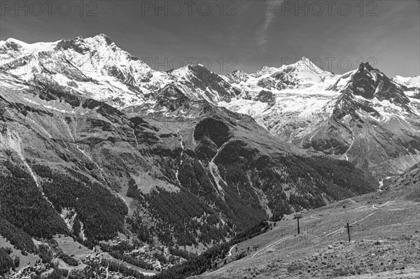 Alpine meadows at the summit of Corne de Sorebois, behind the snow-covered peaks of Weisshorn,