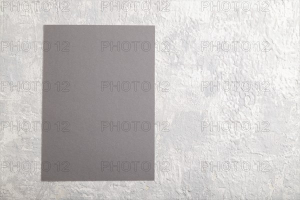 Gray paper business card, mockup on gray concrete background. Blank, flat lay, top view, still