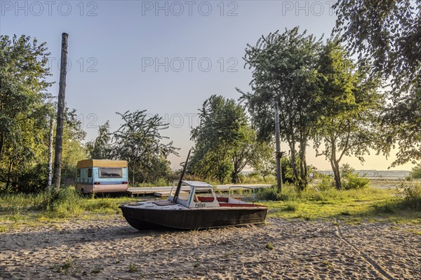 View of the natural beach with boat and old caravan. Peenemünde peninsula on the island of Usedom,