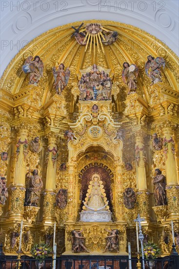 Üppiger barocker Altar mit goldenen Verzierungen und religiösen Statuen in einer Kirche, heilige