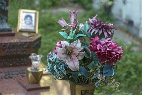 Faded plastic flowers on a grave in the Staglieno Monumental Cemetery, Cimitero Monumentale di