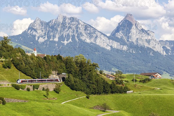 Railway passenger train of the type Stadler Flirt of the Südostbahn on the mountain Großer Mythen