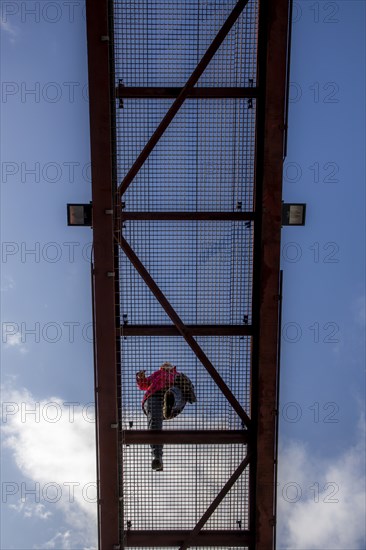 Lattice walkway, people walk over a walkway at a height of a good 15 metres, made of steel lattice,