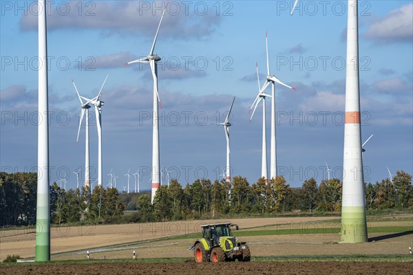 Farmer working in the fields, with a tractor, wind farm above the village of Lichtenau,