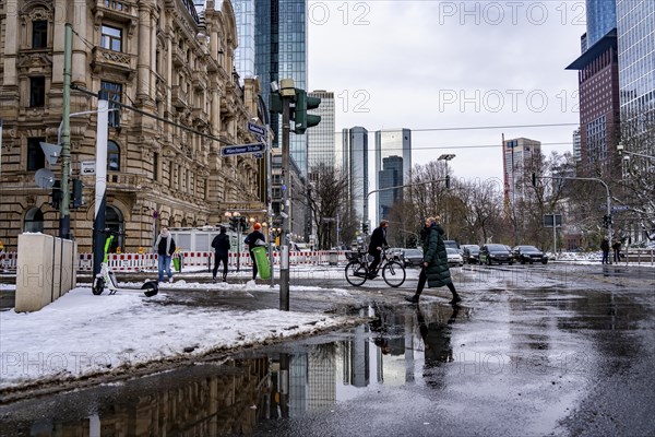 Winter in the city, Gallusanlage street, puddles, pools of water, melt water, pedestrians,