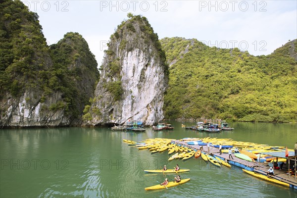 Yellow kayaks at a jetty and the karst rocks in Lan Ha Bay, Halong Bay, Vietnam, Asia
