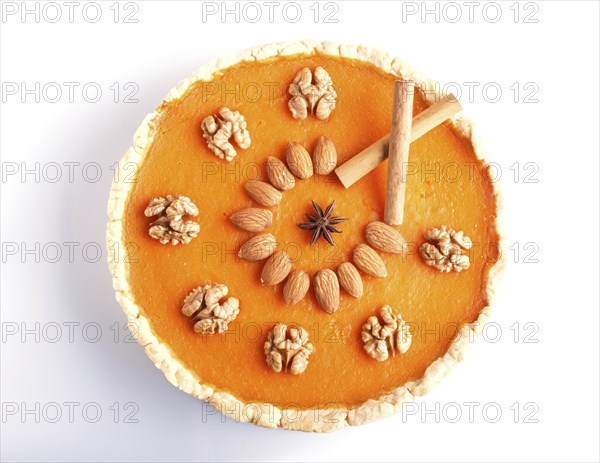 Traditional american sweet pumpkin pie decorated with nuts, isolated on white background. top view
