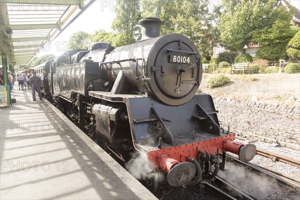 BR Standard Class 4 80104 steam locomotive train engine at platform of railway station, Swanage,