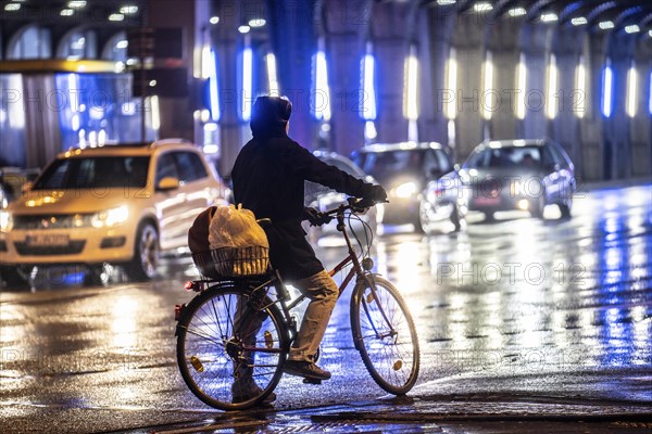 Street at the central station, cyclist, rainy weather, city centre, in the evening, Essen, North