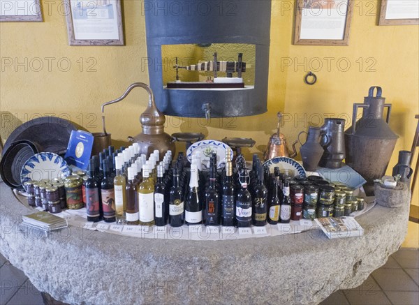 Antique display of products and bottles on a stone table in front of a yellow wall, products from