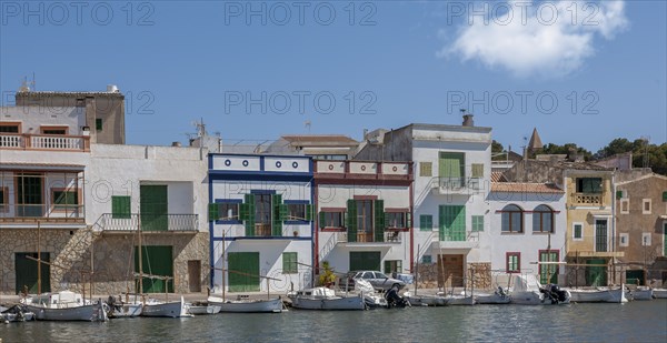 Colourful buildings at the harbour with boats in the foreground and clear sky in the background,
