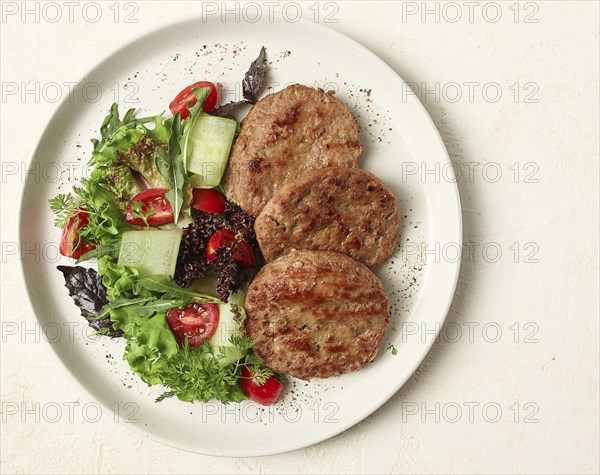 Fried cutlets, minced beef, with vegetable salad, top view, no people