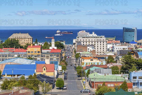 View from a hill over streets and houses to the Strait of Magellan, ships and a tanker in the