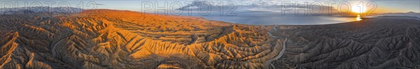 Panorama, river bed runs through a landscape of eroded hills at Lake Issyk Kul, badlands at