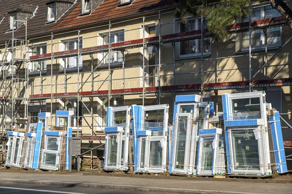 Energy-efficient refurbishment of residential buildings, older apartment block is scaffolded, gets