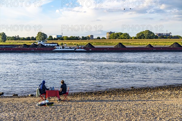 The Rhine at Duisburg-Baerl, man and woman having a picnic on the Rhine beach, at low tide, on the