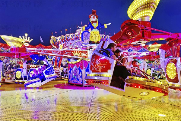 People in the illuminated carousel Circus Circus in the evening, Cranger Kirmes, Herne, Ruhr area,
