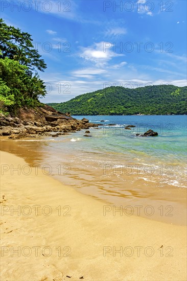 Remote and paradisiacal beach in Trindade, municipality of Paraty, surrounded by hills and tropical