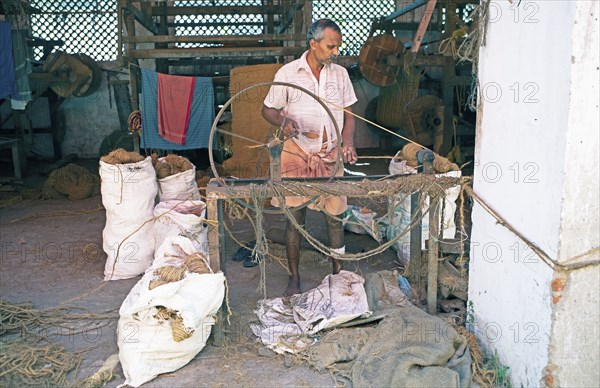 Indian worker winding coils in the Labourers Coir Mats and Mattings Cooperation, coir mat