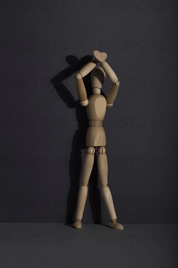 Wooden mannequin stands with raised hands on gray background. protest, attention concept. copy