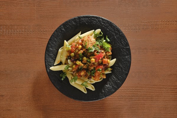 Overhead view of plate with beef slices fried with vegetables and spicy sauce with pasta