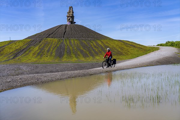 Cyclist on the Rheinelbe spoil tip in Gelsenkirchen, 100 metre high spoil tip, landscape park, with
