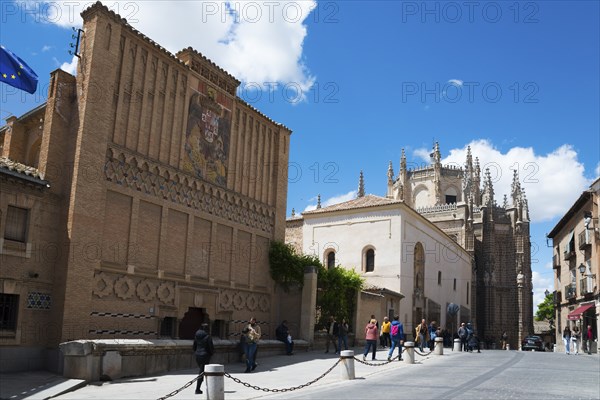Pedestrian zone in Toledo with historic buildings and a Gothic church under a blue sky, art school,
