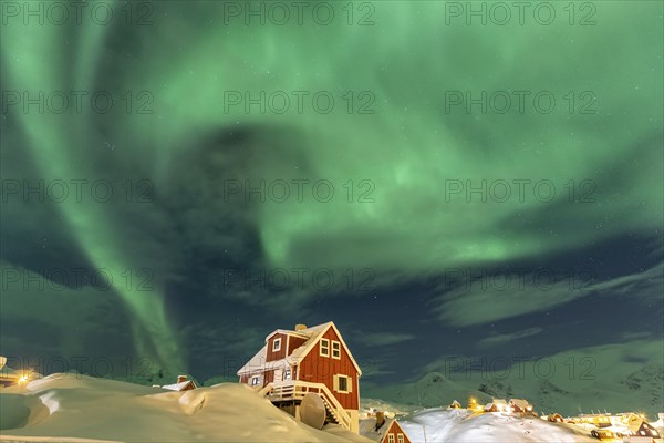 Northern Lights, Aurora borealis over red house, Inuit settlement, Winter, Tasiilaq, East